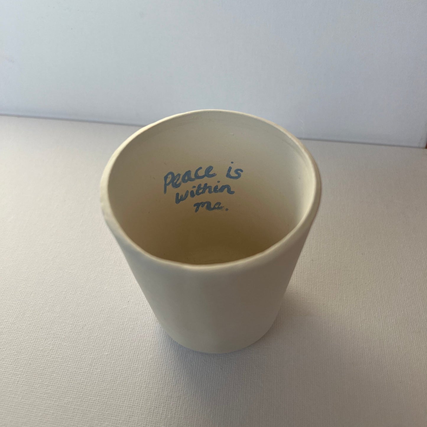 A hand painted porcelain cup - A Cup with a message